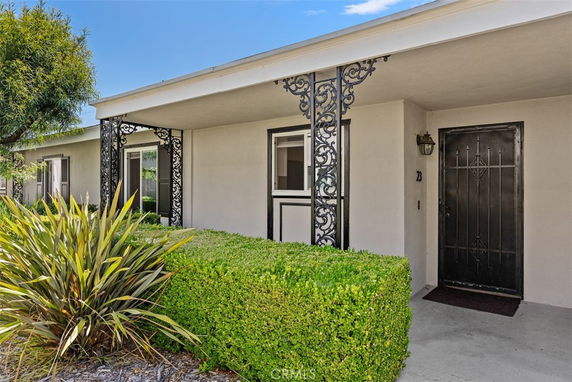 Front view of a house with decorative metal columns and a covered entrance.
