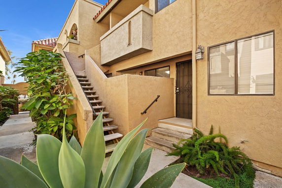 Front view of a two-story building with stairs and a balcony.
