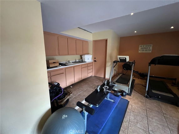 Indoor gym area with exercise equipment and storage cabinets.