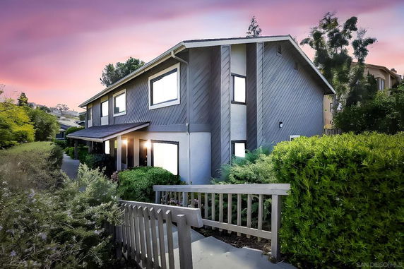 Front view of a two-story house with a sloped roof and entrance path.