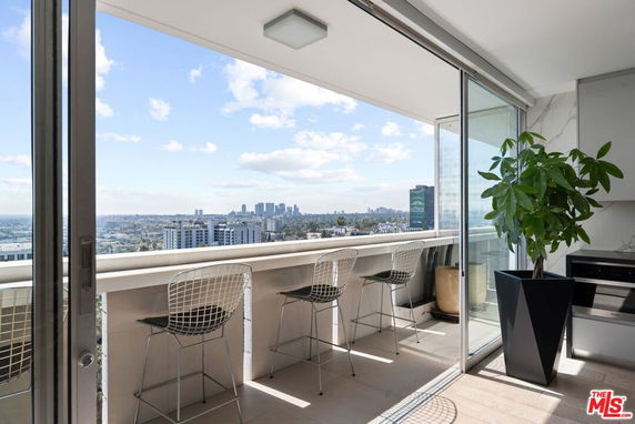 Balcony view overlooking cityscape with tall buildings in the distance.