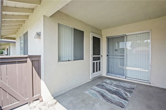 Front view of a house with a covered entrance and sliding doors.