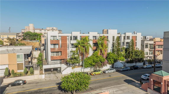 Front view of a multi-story apartment building with balconies and varied facade design.
