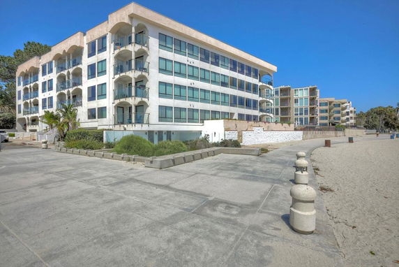 Front view of a multi-story beachfront building with balconies.