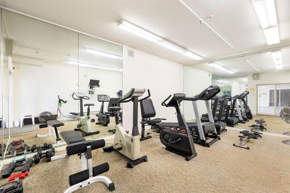 Indoor gym area with exercise equipment including treadmills and stationary bikes.
