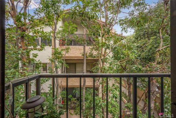 View from a balcony showing a multi-story building with trees around.