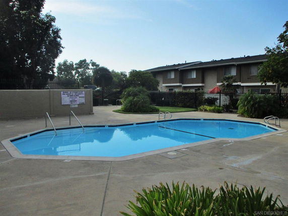 Outdoor swimming pool area with surrounding buildings.
