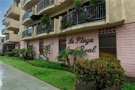 Front view of a multi-story building with balconies and landscaped front.