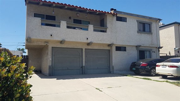 Front view of a two-story house with a double garage and a balcony.