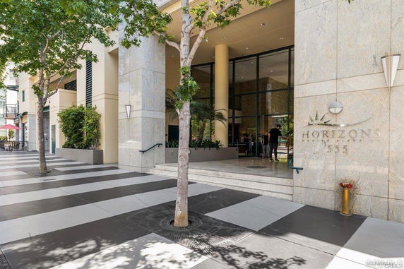 Front view of a modern building entrance with large glass windows and a sign reading 'Horizons 555'.
