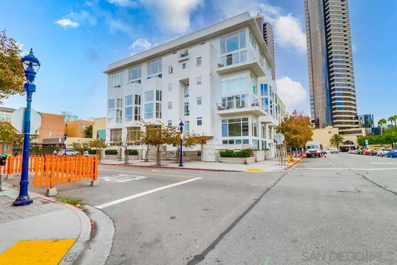 Front view of a multi-story residential building on a street corner.