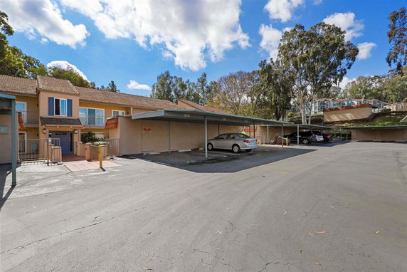 Outdoor parking area with parked cars and adjacent residential buildings.