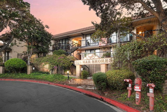 Front view of a two-story residential building with a sign reading 'Del Mar Shores'.