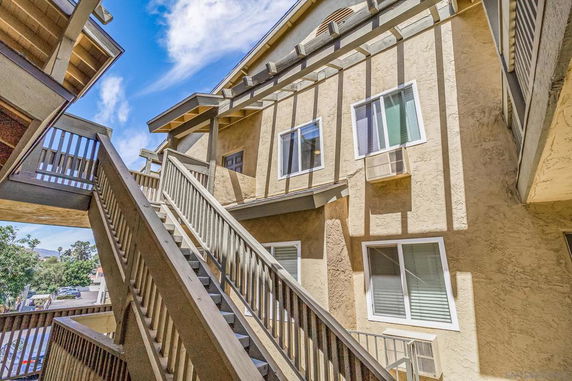 View of a multi-story building with external staircases and windows.