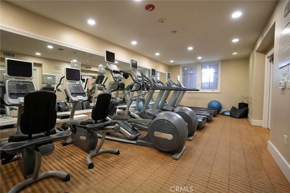 Indoor gym area with exercise equipment and mirrors.