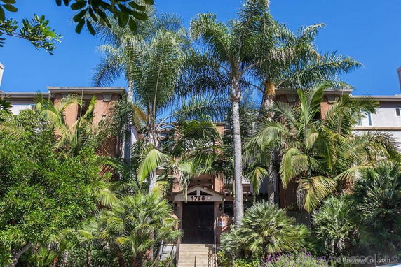 Front view of a multi-story building with palm trees.