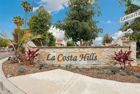 Entrance sign of La Costa Hills with landscaping and building structures in the background.