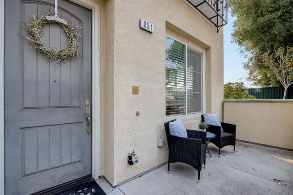 Front view of a house with a door, window, and small outdoor seating area.
