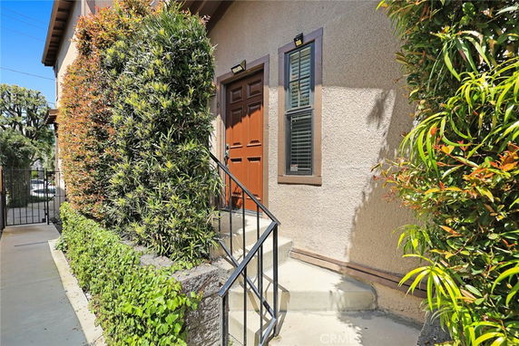 Front view of a house entrance with steps and a wooden door.