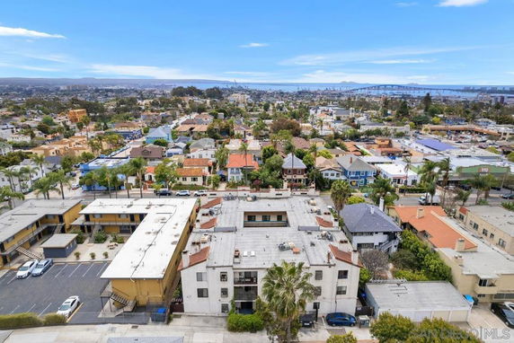 Panoramic view of residential area with multiple buildings and distant cityscape.