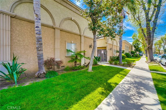 Side view of a building with arched windows and stucco exterior.