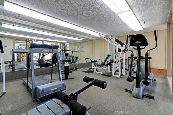 Indoor gym with exercise equipment including treadmills and weight machines.