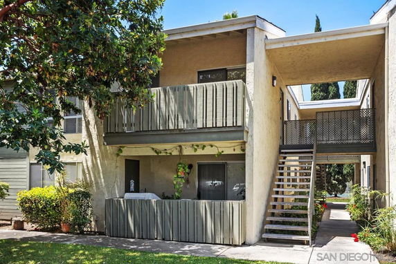 Front view of a two-story apartment building with balconies and an external staircase.