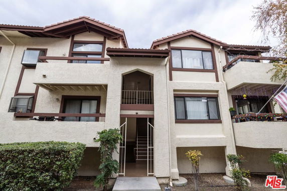 Front view of a multi-story residential building with balconies.
