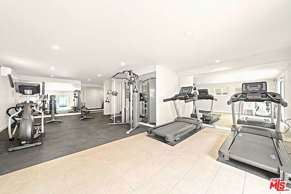 Indoor gym area with exercise equipment including treadmills and strength machines.