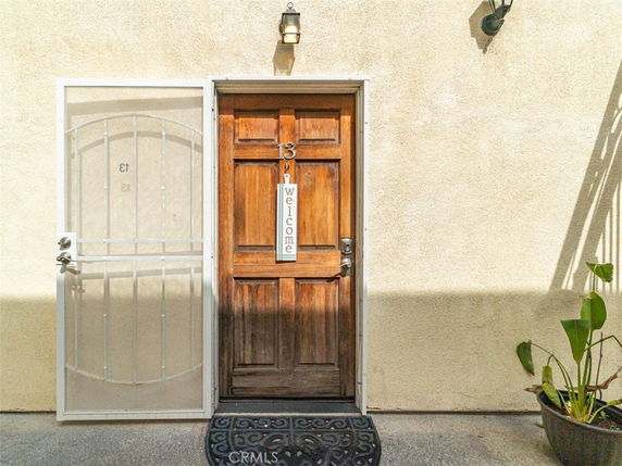 Front view of a house entrance with a wooden door and a security gate.