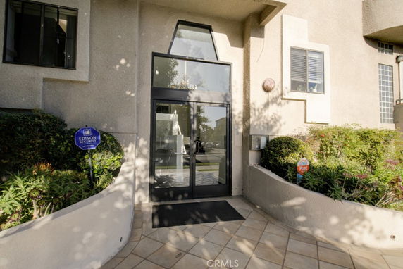 Entrance view of a modern building with glass door and windows.