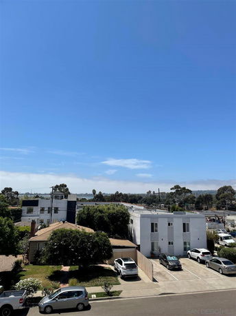 View of residential area with multiple buildings and parked cars.