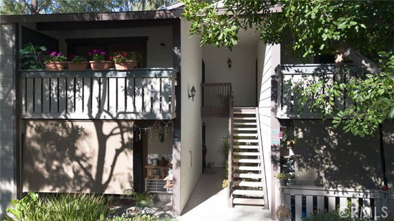 Front view of a two-story building with balconies and exterior staircase.
