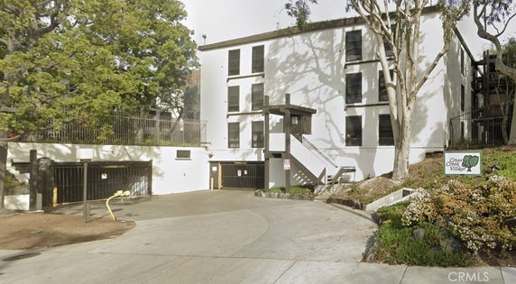 Front view of a multi-story building with a drive-up entrance and garage space.
