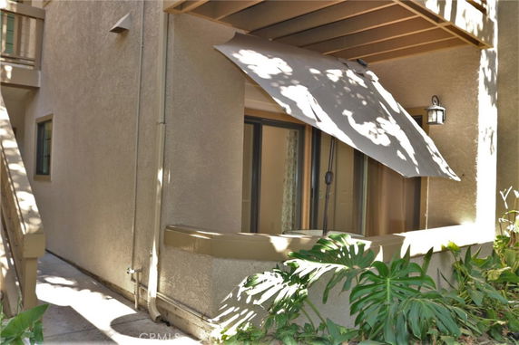 Front view of a building corner with an awning over a window.