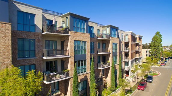 Front view of a multi-story apartment building with balconies.