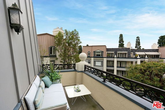 View from a balcony overlooking a complex with multiple buildings and greenery.