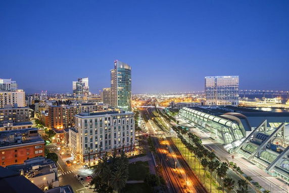 Panoramic view of a cityscape with skyscrapers and a convention center at night.