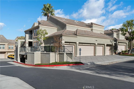 Front view of a two-story house with a staircase and multiple garages.