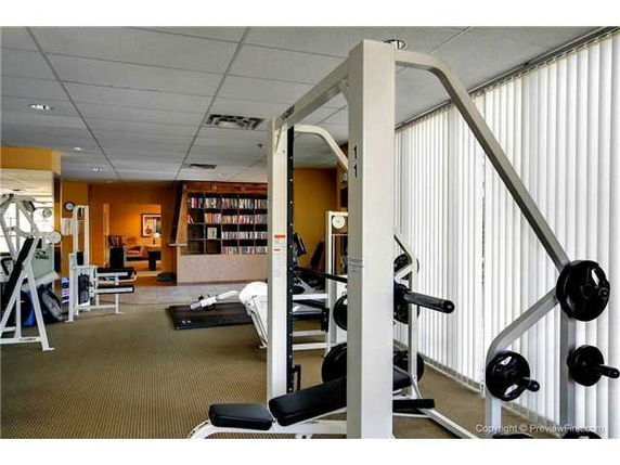 Room with fitness equipment and bookshelves.