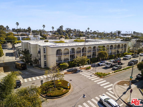 Front view of a multi-story building with arched balconies.