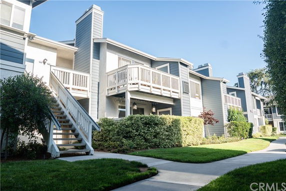 Front view of a multi-story residential building with balconies and exterior staircases.