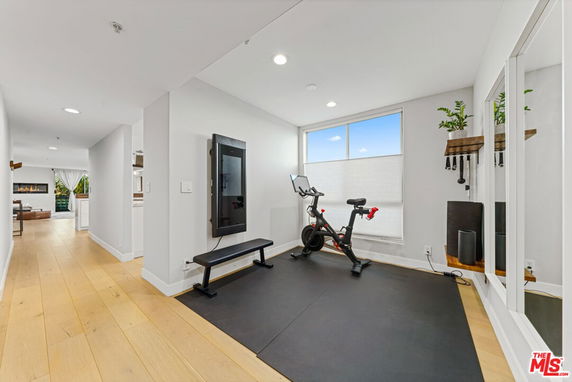 Indoor exercise area with a bicycle and workout mirror.