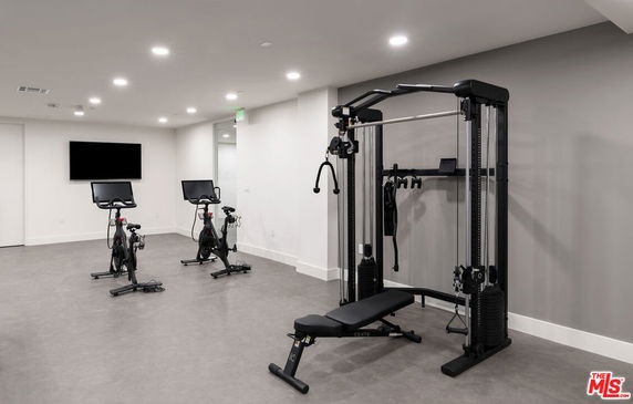 Indoor gym with exercise bikes and strength training equipment.
