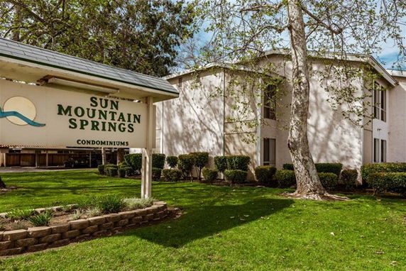 Front view of a condominium building with a sign for Sun Mountain Springs.