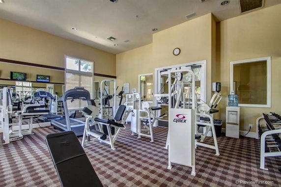 Indoor gym area with exercise equipment and machines.