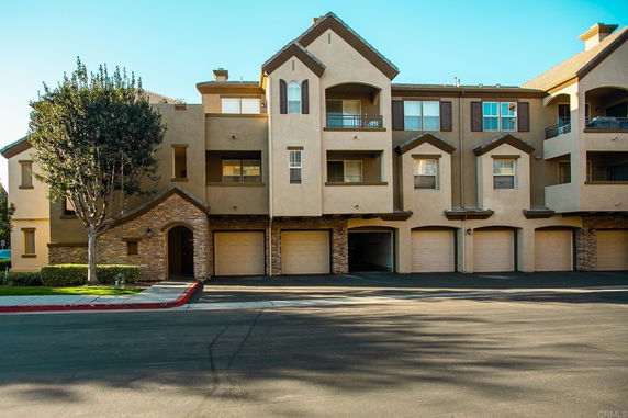 Front view of a multi-story residential building with garages.