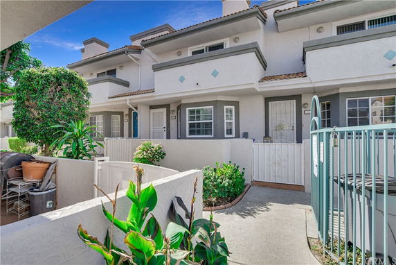 Front view of a modern multi-story townhouse with a small gated entrance.