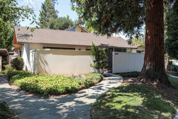 Front view of a single-story house with a fenced yard.
