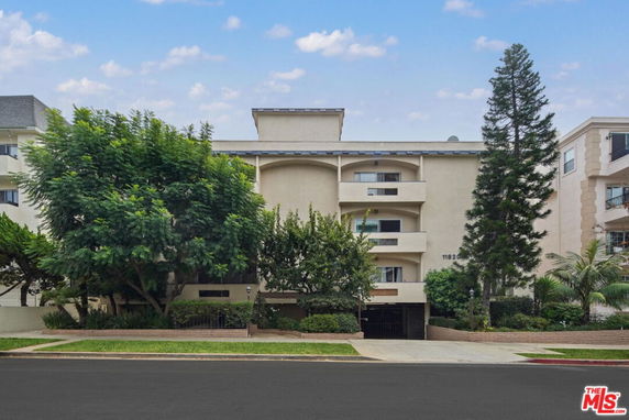 Front view of a multi-story building with balconies and a central entrance.